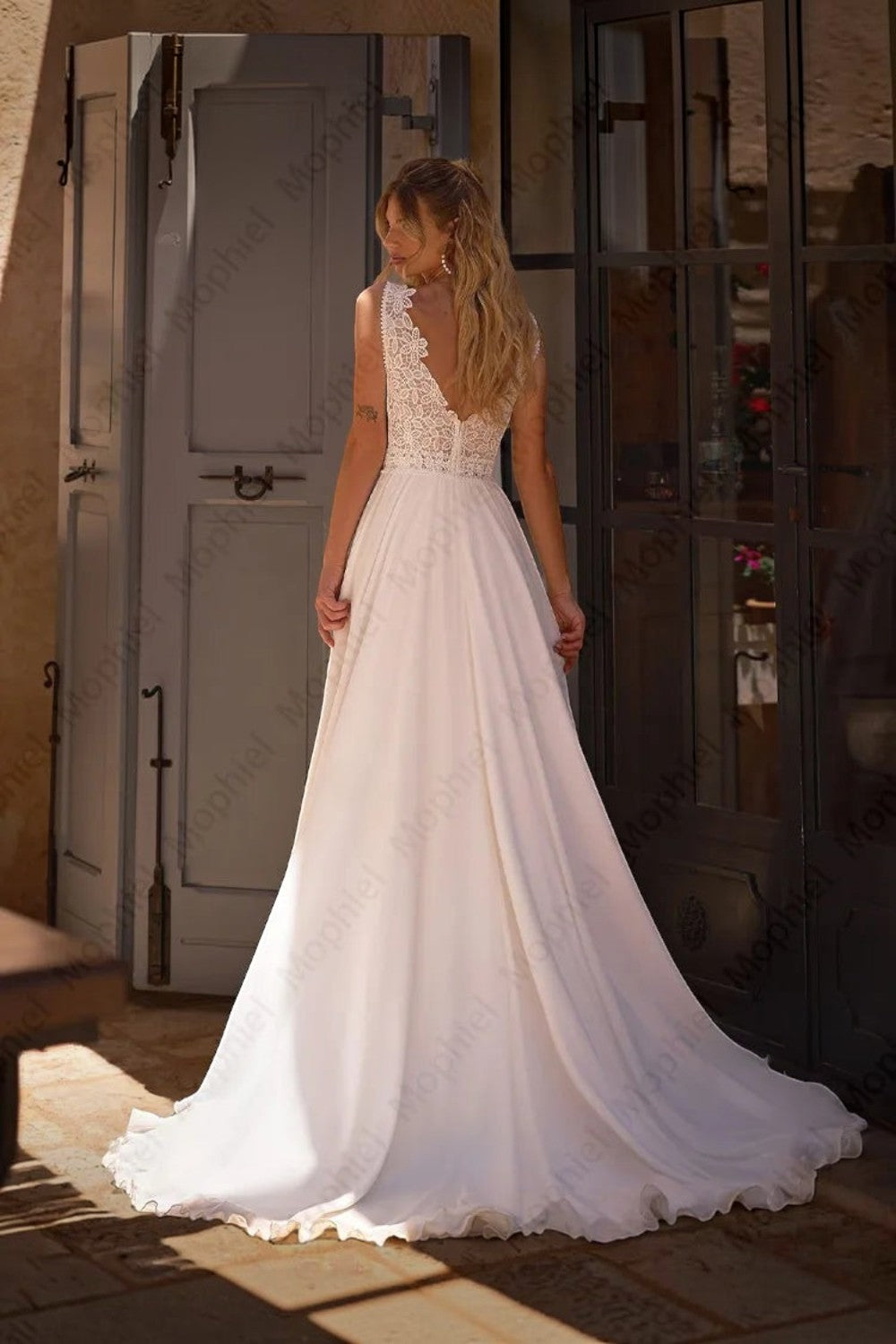 TheBlissWedding white chiffon A-line wedding dress with a sleeveless lace bodice and V-back detail.
