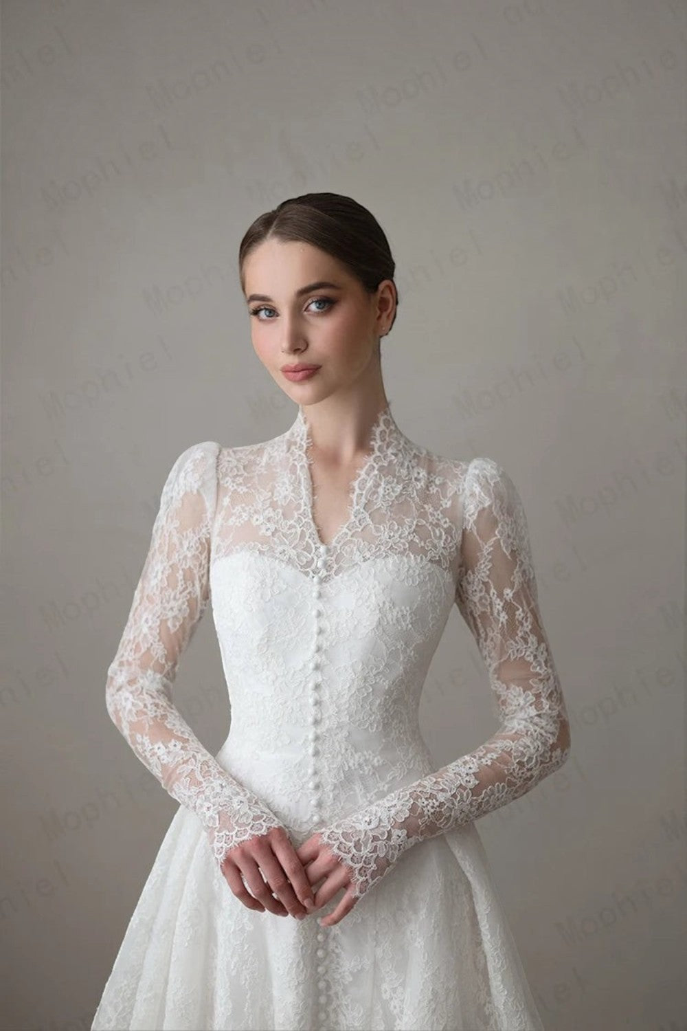 TheBlissWedding white lace A-line bridal gown with a high collar, long illusion sleeves, and delicate button details.