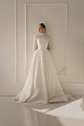 TheBlissWedding modest A-line bridal gown with high neck, long lace sleeves, and a sweep train in ivory lace.