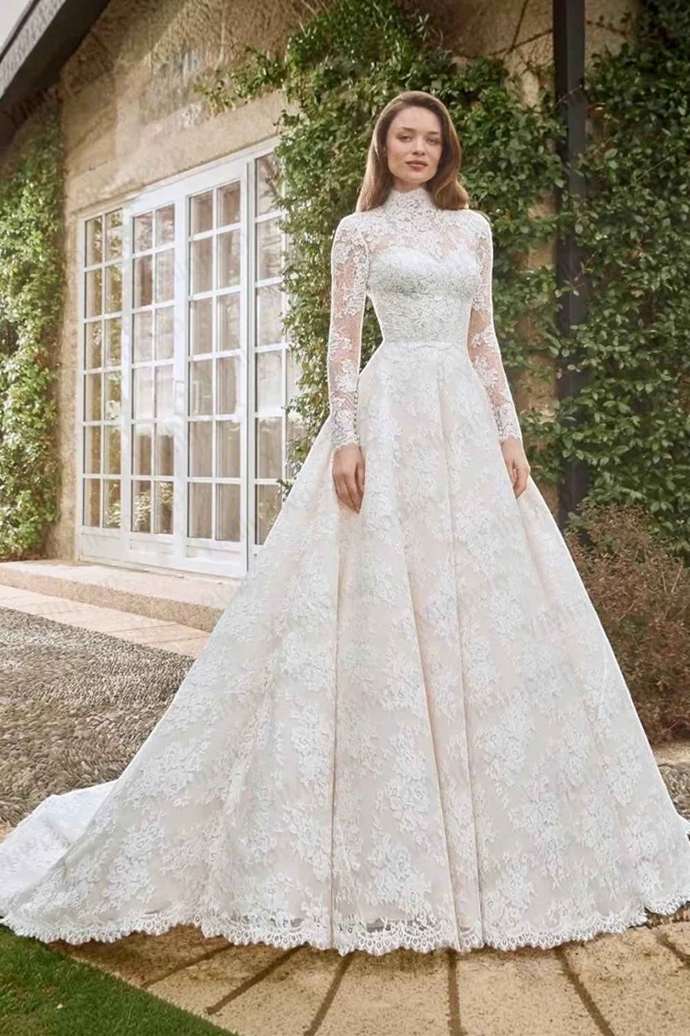 TheBlissWedding white lace A-line wedding dress with high neck, long sleeves, and sweep train in a garden setting.