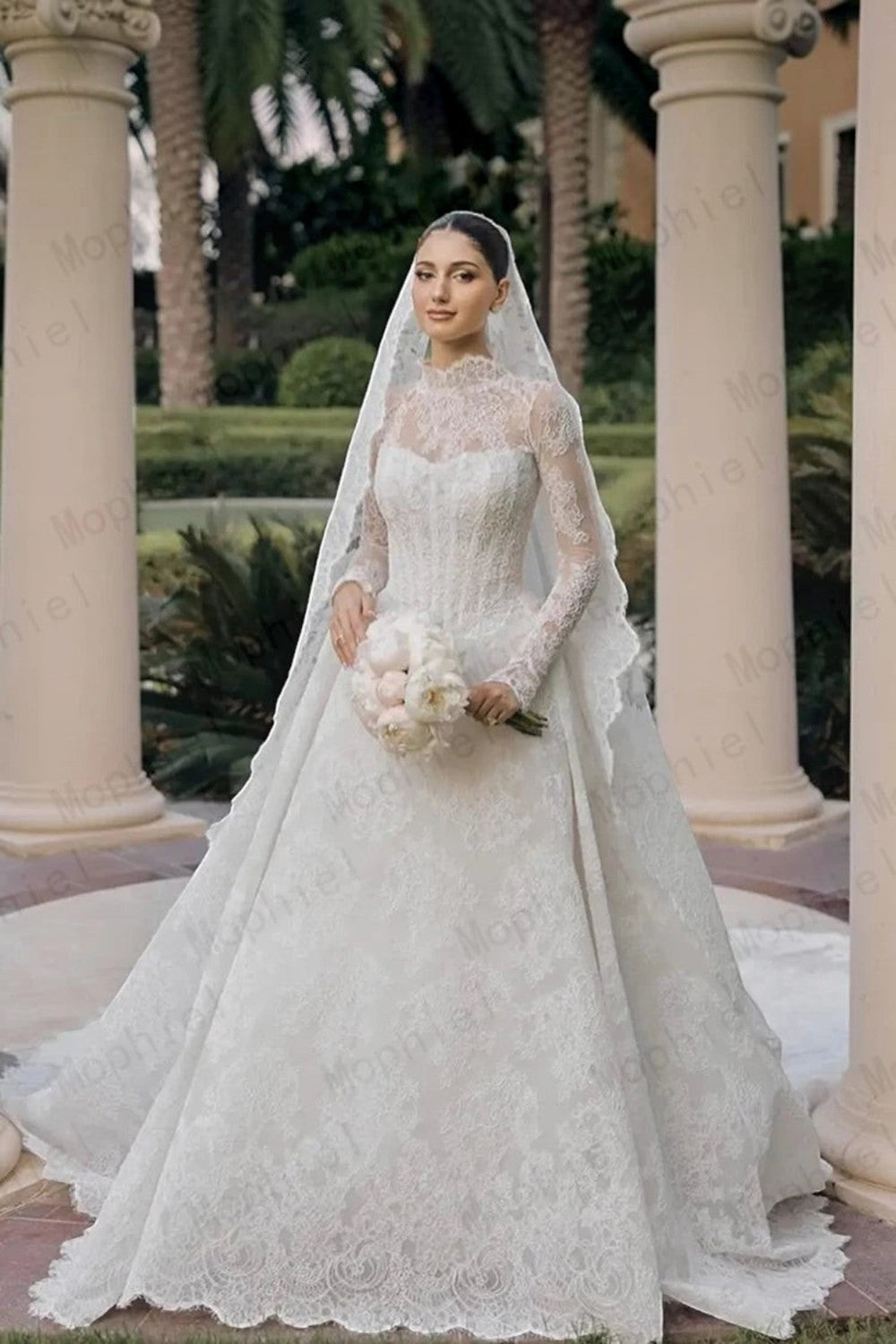 TheBlissWedding white lace A-line wedding dress with long sleeves, high neckline, and veil in a garden setting.