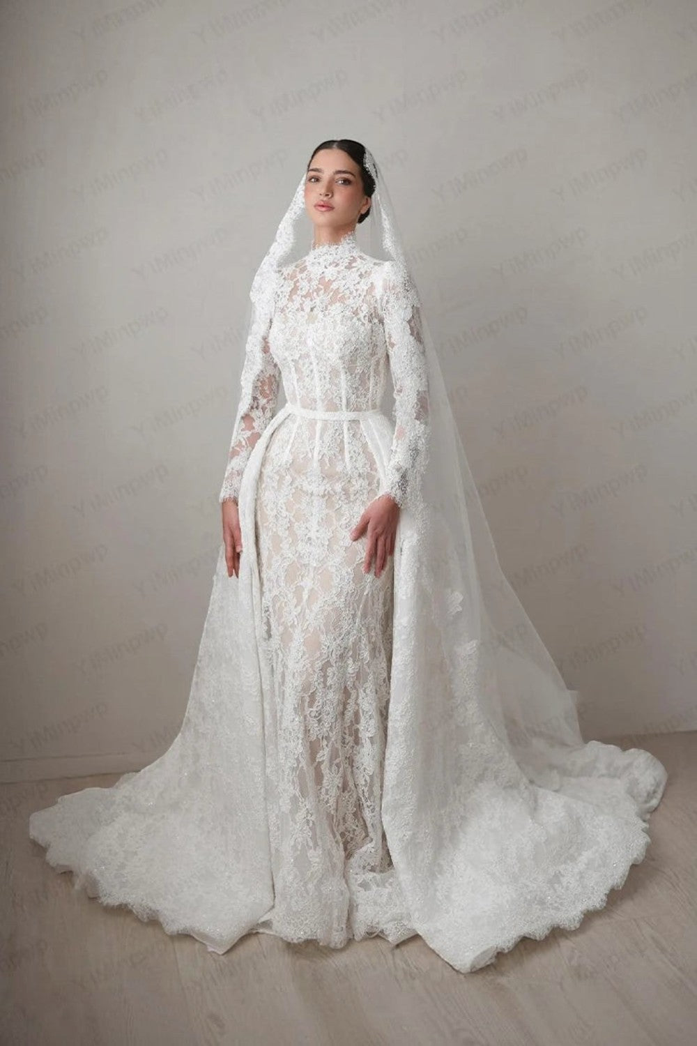 TheBlissWedding white lace mermaid wedding dress with high neck, long sleeves, and a detachable train on a model.