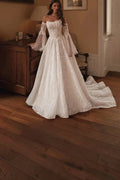 TheBlissWedding off shoulder lace A-line bridal gown with detachable flare sleeves and a sweep train in ivory.
