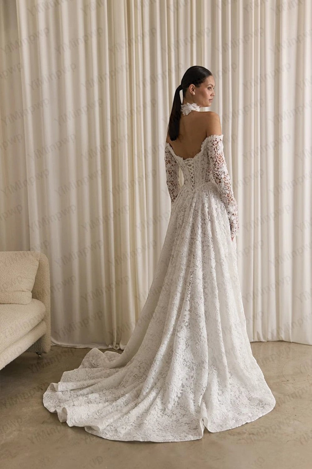 TheBlissWedding white lace off-shoulder wedding dress with long sleeves, backless design, and a flowing A-line skirt.