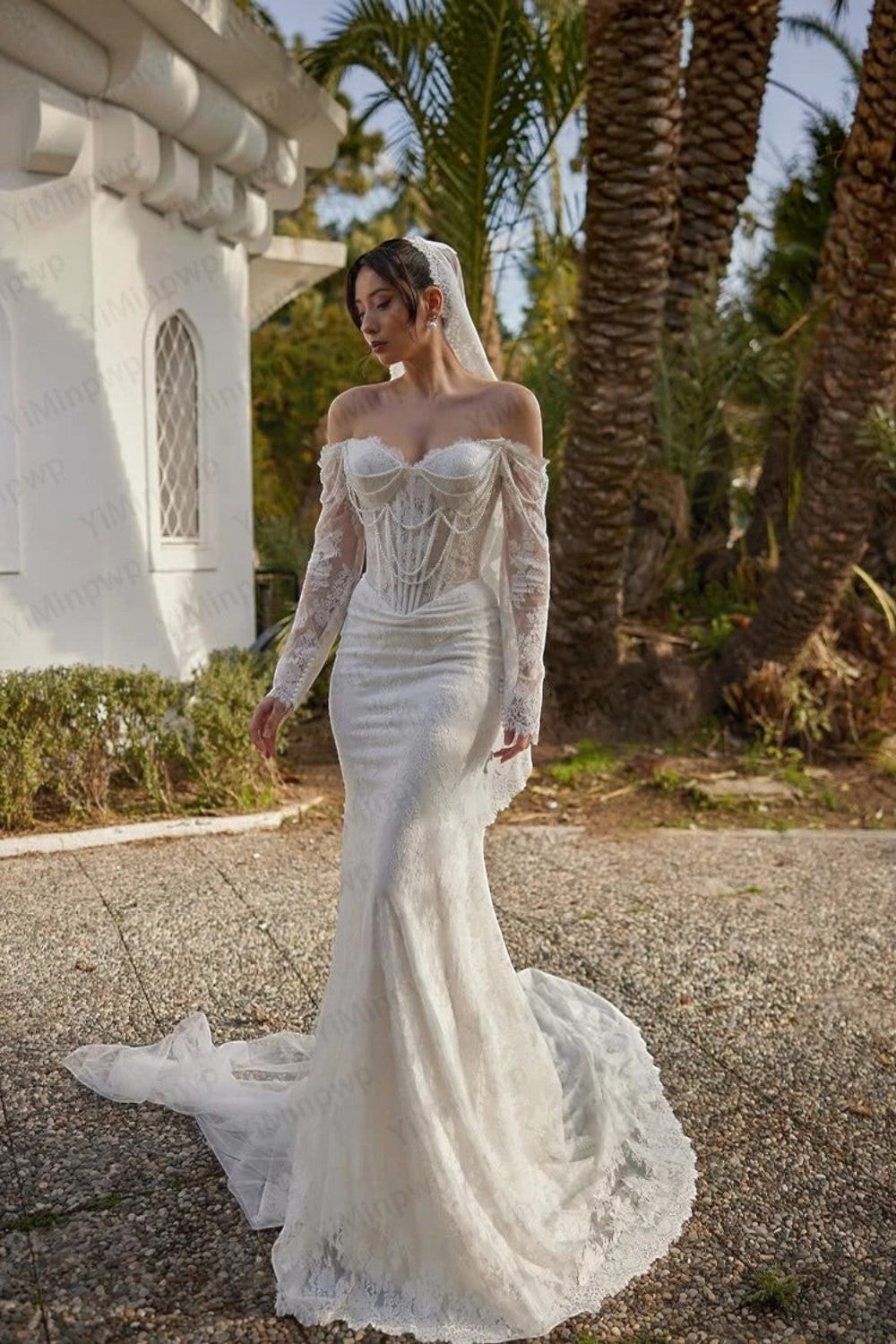 TheBlissWedding off-shoulder mermaid bridal gown with long lace sleeves, pearl embellishments, and a sweep train.