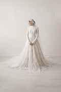TheBlissWedding white modest wedding dress with high collar, long lace sleeves, and A-line skirt with a sweep train.