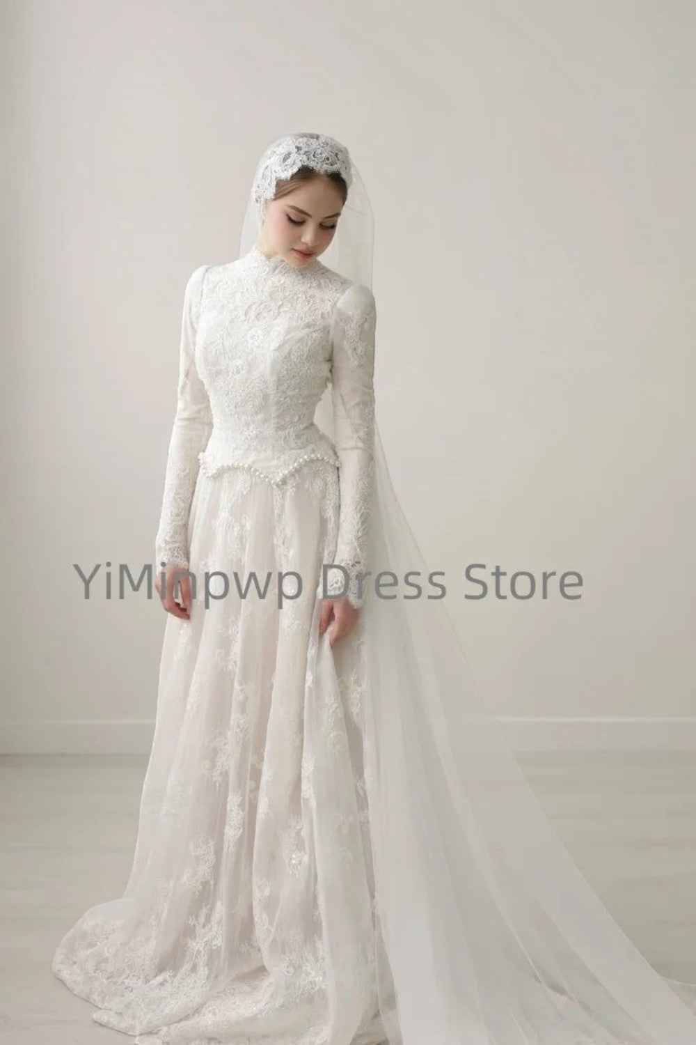 TheBlissWedding modest white A-line wedding dress with high collar, long lace sleeves, and matching lace headpiece.