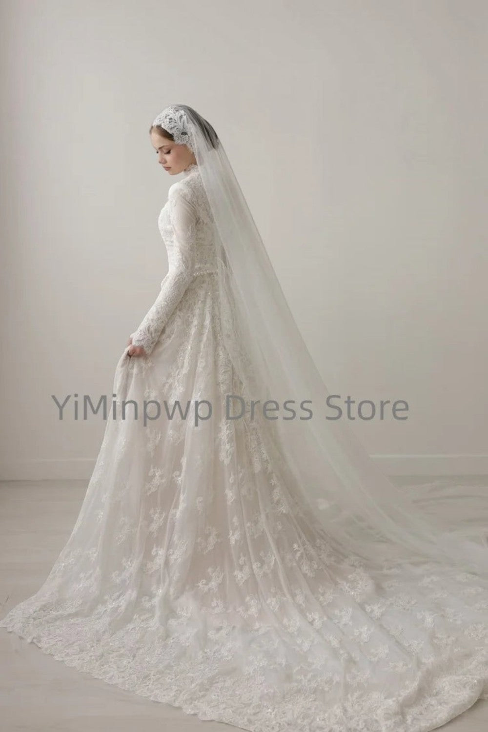 TheBlissWedding white modest A-line wedding dress with high collar, long lace sleeves, and a long bridal veil.
