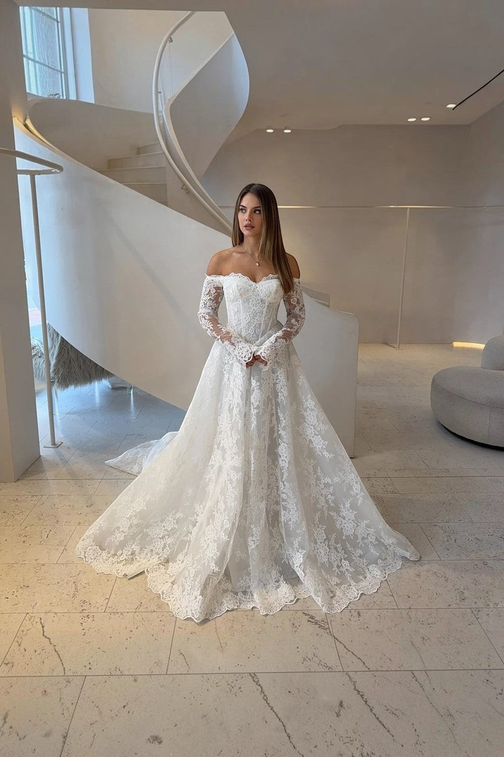 TheBlissWedding white A-line wedding dress with off-shoulder neckline, long lace sleeves, and a graceful sweep train.