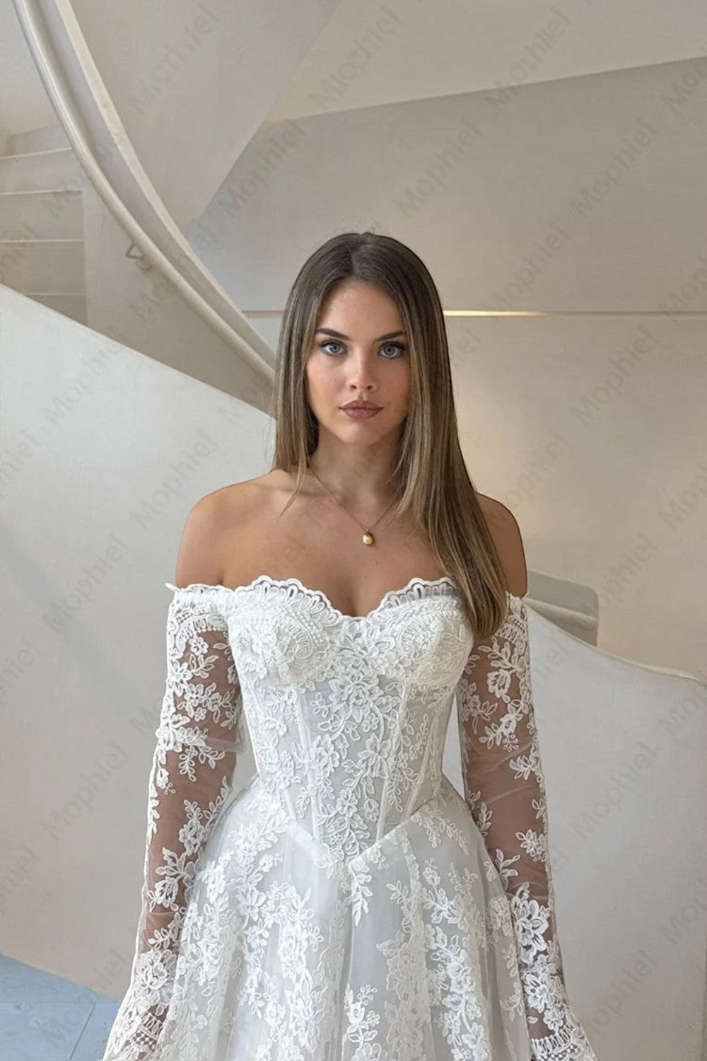 TheBlissWedding white off-shoulder bridal gown with long lace sleeves and a corset-style bodice on a model.