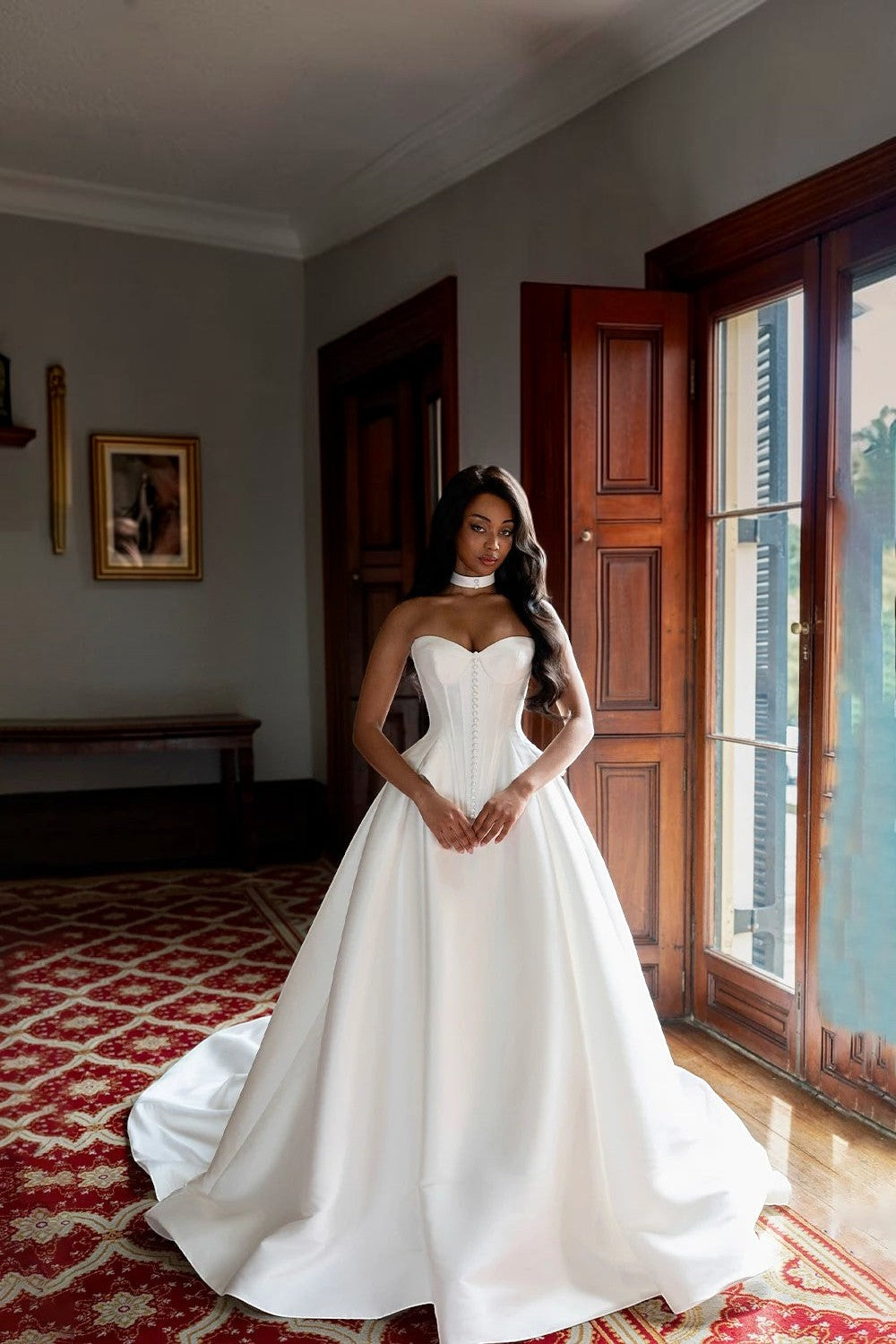 TheBlissWedding white satin A-line wedding dress with a sweetheart neckline and sleeveless bodice in a classic room.