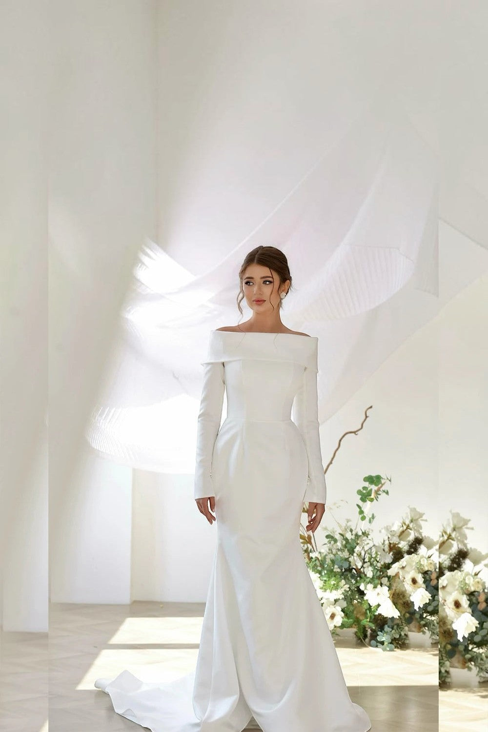 TheBlissWedding white satin mermaid wedding dress with off-shoulder neckline, long sleeves, and a detachable train.