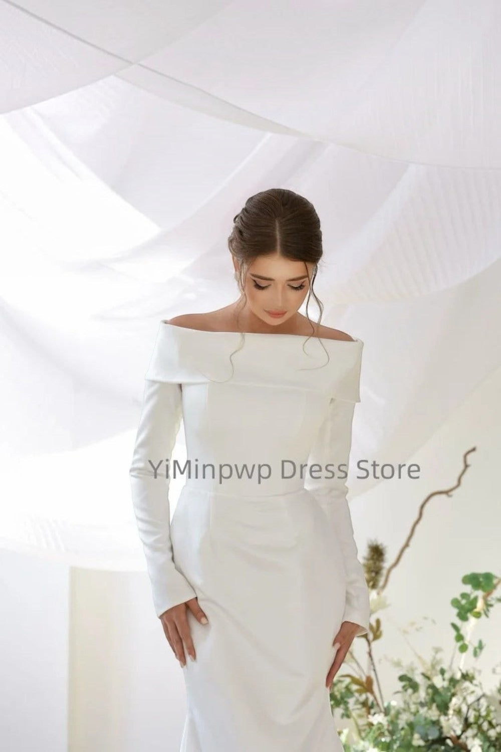 TheBlissWedding white satin mermaid wedding dress with off-shoulder neckline and long sleeves on a bride.