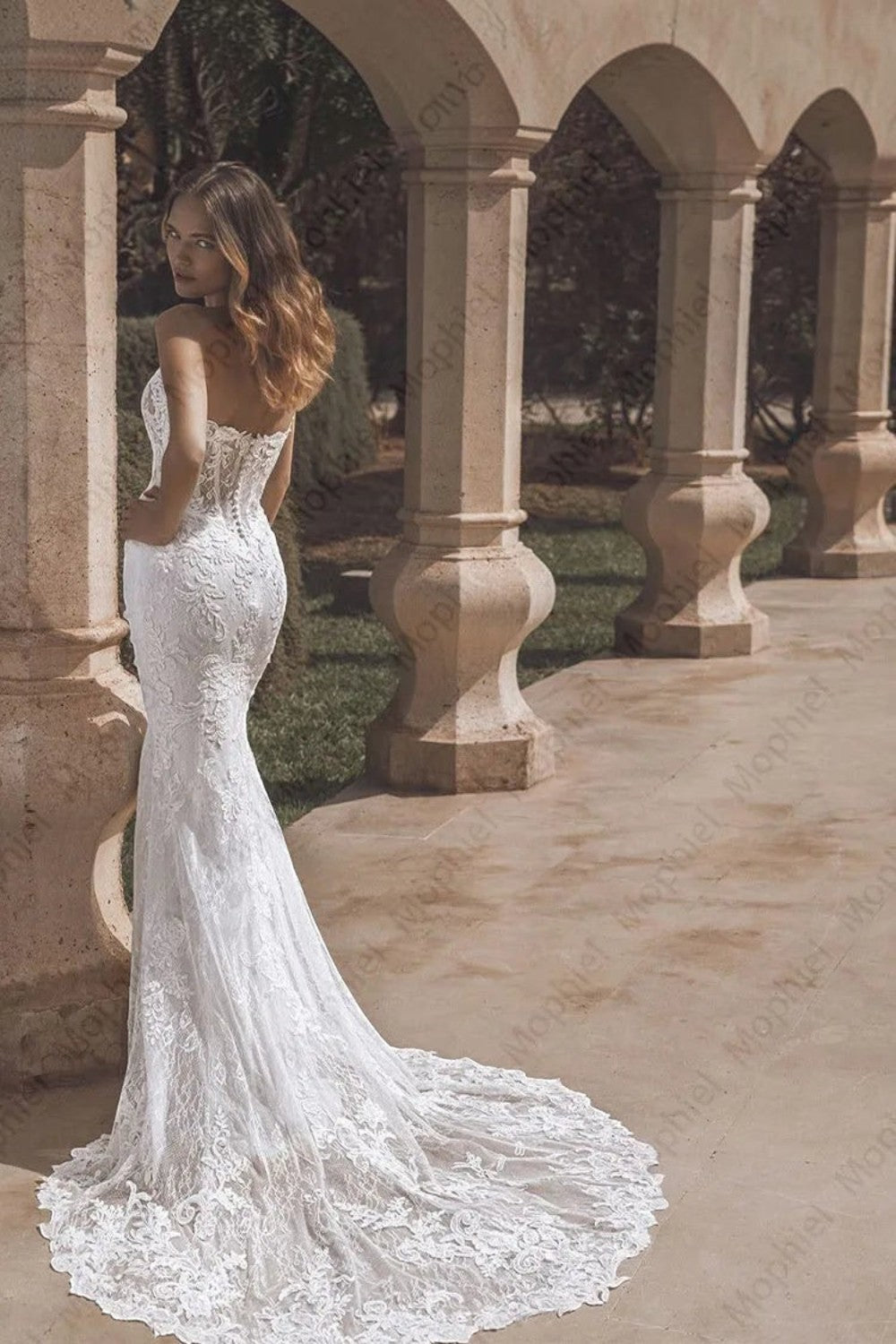 TheBlissWedding strapless mermaid bridal gown with intricate lace appliques and a dramatic floor-length train.